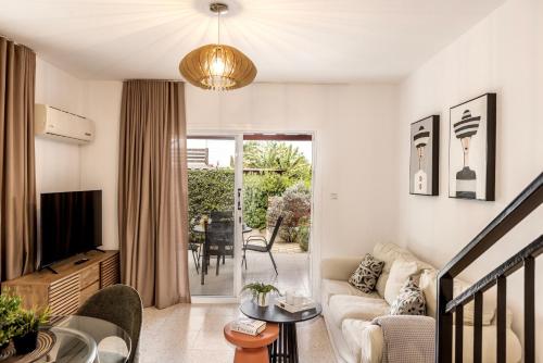 a living room with a couch and a tv at Larnaca Seaside Villa Marina 43 in Perivolia