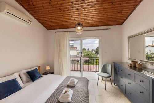 ein Schlafzimmer mit einem Bett, einem Fenster und einem Stuhl in der Unterkunft Larnaca Seaside Villa Marina 43 in Perivolia