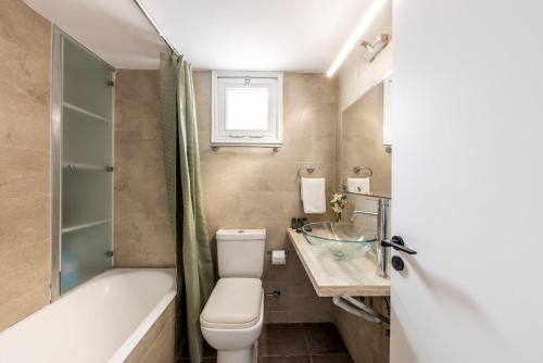 ein Badezimmer mit Toilette, Badewanne und Waschbecken in der Unterkunft Larnaca Seaside Villa Marina 43 in Perivolia