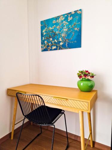 a desk with a chair and a vase of flowers at Dimora Odigitria in Bitritto