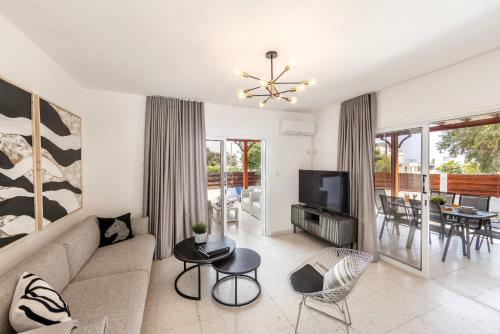 a living room with a couch and a television at Larnaca Seaside Villa Marina 44 in Perivolia