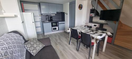 une petite cuisine et salle à manger avec une table et des chaises dans l'établissement Résidence Front de Mer, Appt 5 couchages, au Barcarès