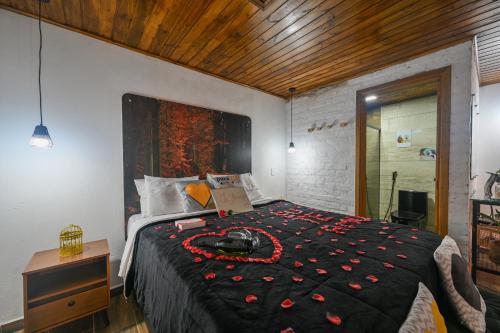 a bedroom with a bed with a black comforter at Recanto Lira 1 e 3 in Monte Verde