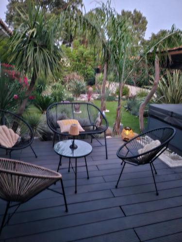 d'une terrasse avec quatre chaises et une table. dans l'établissement L orangerie de casaoma, à Prunelli-di-Fiumorbo
