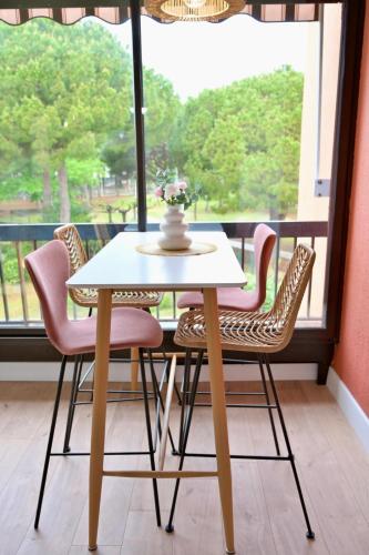 une table et des chaises devant une fenêtre dans l'établissement studio coquet grau du roi, au Grau-du-Roi
