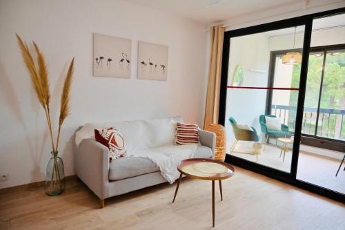 un salon avec un canapé et une table dans l'établissement studio coquet grau du roi, au Grau-du-Roi