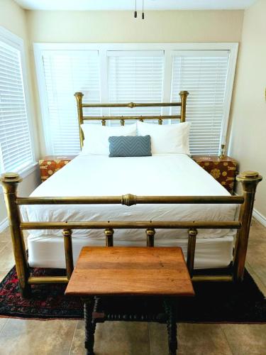a bed with a wooden frame and a wooden table at Craftsman by Downtown Uvalde in Uvalde