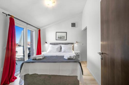 a bedroom with a large bed with red curtains at Apartments 2 with pool and private jacuzzi in Vodice