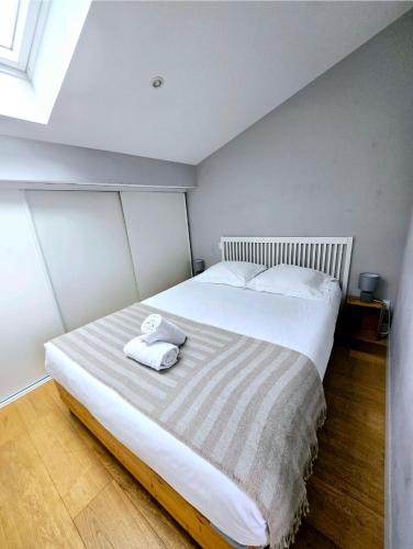 une chambre avec un grand lit avec deux serviettes dessus dans l'établissement Grand Théâtre Apartment, à Bordeaux