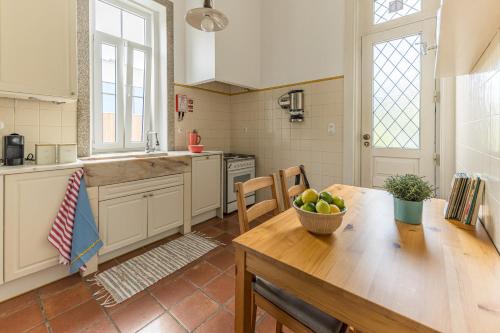 a kitchen with a table with a bowl of fruit on it at Vila Mar Beach House in Arcozelo