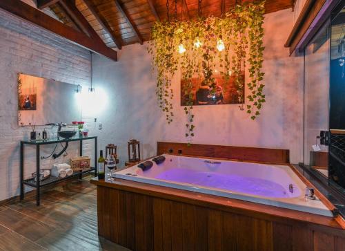 a large bathroom with a large tub in a room at Recanto Lira 1 e 3 in Monte Verde