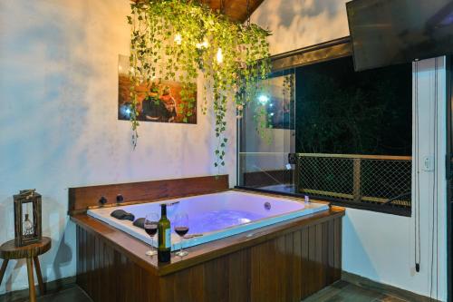 a jacuzzi tub in a room with a window at Recanto Lira 1 e 3 in Monte Verde