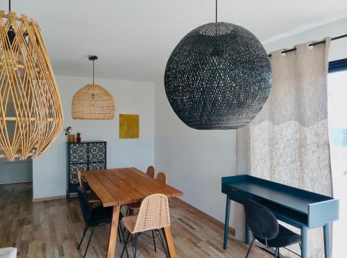 une salle à manger avec une table et un piano dans l'établissement SOZEN - Maison bois récente, lumineuse avec terrasse et grand Jardin, proche des plages, à Tréogat