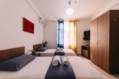 a hotel room with two beds and a tv at Hotel Skrapari in Çorovodë
