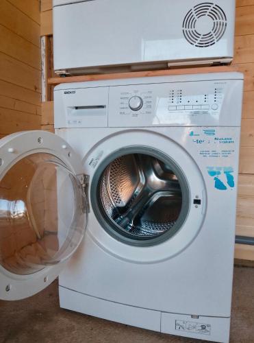 Un lave-linge est installé à côté d'un lave-linge. dans l'établissement SOZEN - Maison bois récente, lumineuse avec terrasse et grand Jardin, proche des plages, à Tréogat
