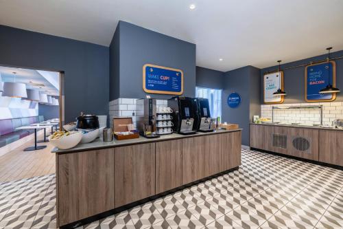 a restaurant with a counter with a coffee shop at Holiday Inn Express Aberdeen Airport by IHG in Dyce