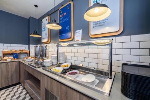a restaurant kitchen with a counter with food at Holiday Inn Express Aberdeen Airport by IHG in Dyce