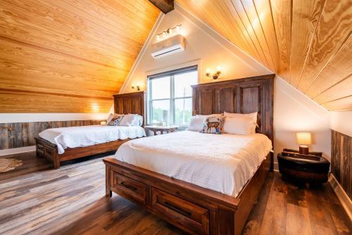 two beds in a room with wooden ceilings at Peletah Escape – Peaceful Bluegrass Getaway in Waddy