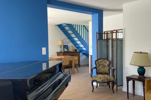 un salon avec un mur bleu et un escalier dans l'établissement Spacious house near the beach Saint-Lunaire, à Saint-Lunaire