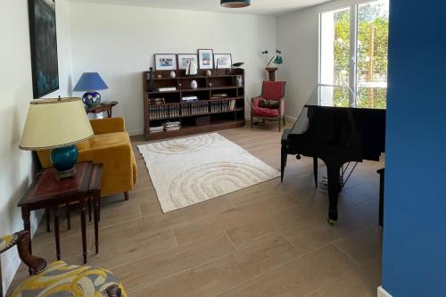 - un salon avec un piano et une chaise dans l'établissement Spacious house near the beach Saint-Lunaire, à Saint-Lunaire