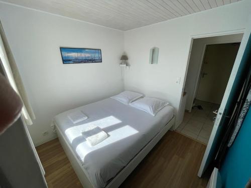 - une petite chambre blanche avec un lit dans l'établissement Agréable T2 climatisé, terrasse,wifi,piscine, à Bandol