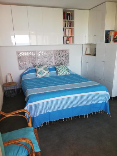 - une chambre avec un lit doté de draps bleus et de placards blancs dans l'établissement vue mer et montagne, accès direct plage, à Leucate-Plage