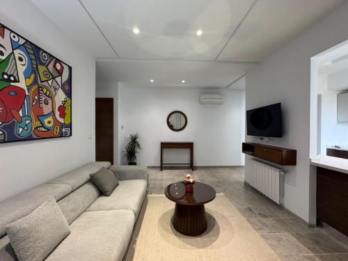 a living room with a couch and a table at Appartement a jardin carthage tunis in Sidi Daoud
