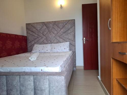 モンバサにあるAisha Luxury Apartmentsのベッドルーム1室(大型ヘッドボード付きのベッド1台付)