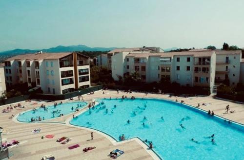 - une grande piscine avec des personnes à côté des bâtiments dans l'établissement Nid douillet pour vos vacances !, à Fréjus