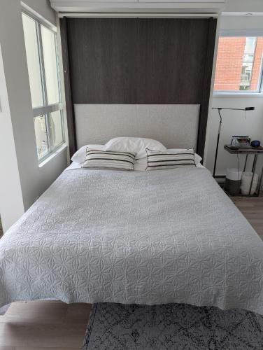 a bedroom with a large bed with two pillows at Executive Studio in Vancouver