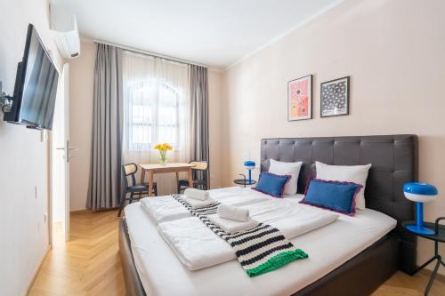 a bedroom with a large bed with blue and white pillows at Vienna Stay Apartments Schönbrunn in Vienna
