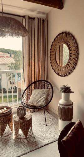 un salon avec une chaise et un miroir dans l'établissement Nid douillet pour vos vacances !, à Fréjus