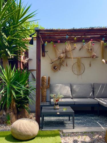 d'une terrasse avec un canapé et une table. dans l'établissement Les Cactus Fréjus Plage, à Fréjus