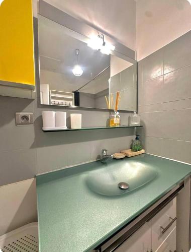 une salle de bain avec un lavabo et un miroir dans l'établissement Chez Lise et Brice - Canet en Roussillon- Appartement vue sur mer, 6 voyageurs, Clim, à Canet