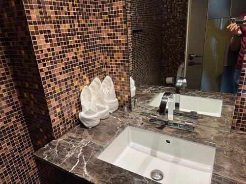 a bathroom with a sink and a mirror at Ultra Luxury Palm Dubai Eye Fendi 2BR Damac Height in Sabkhah