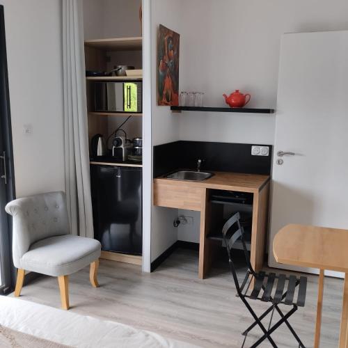 Il comprend une petite cuisine avec un bureau et une chaise. dans l'établissement Le Logis de la Voie Verte, à Saint-Amadou