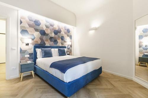 a bedroom with a blue and white bed in a room at Designer Apartment in Oltrarno in Florence