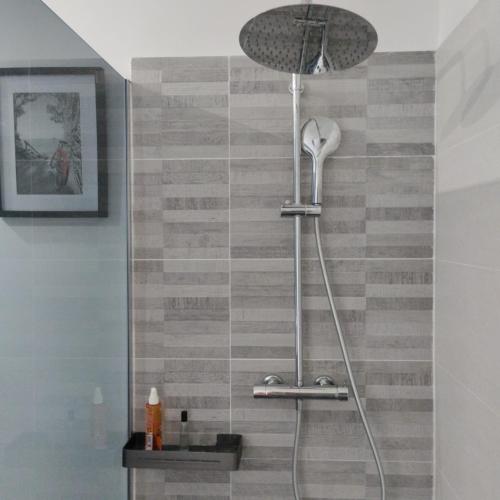 une douche avec pommeau de douche dans une salle de bain dans l'établissement Le Logis de la Voie Verte, à Saint-Amadou