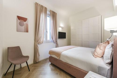 a bedroom with a bed and a chair and a window at Designer Apartment in Oltrarno in Florence