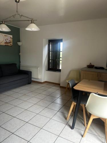 un salon avec une table et un canapé dans l'établissement Le Balcon Beaujolais, à Pouilly-le-Monial