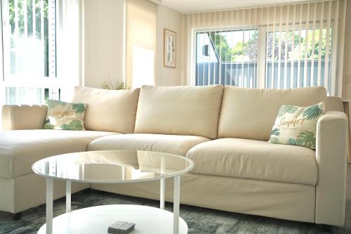 a living room with a white couch and a table at Appartement de charme in Vaux-sur-Sûre