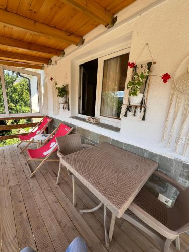 a porch with a table and chairs and a window at Canyon's house in Çorovodë
