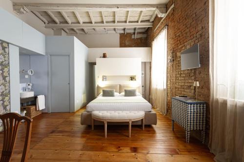 a bedroom with a bed and a couch in a room at Duse in Vigevano