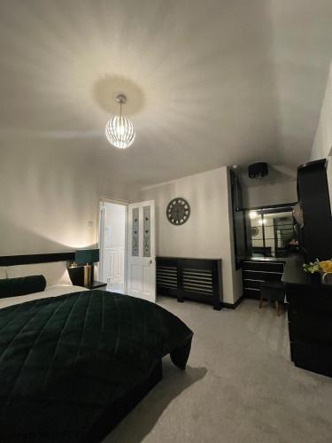 a bedroom with a bed and a clock on the wall at Comfy NEC, Birmingham Airport Stay, Free Parking in Birmingham