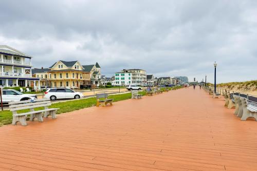 a boardwalk with benches and buildings on a beach at Walk to Downtown and Beach Ocean Grove Apartment! in Ocean Grove
