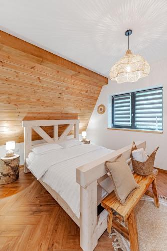 a bedroom with a large bed and a wooden wall at Black Raven Cabin in Topliţa