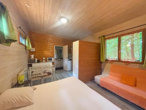 Cette petite chambre comprend un lit et une cuisine. dans l'établissement Écolodge Les Sentiers du Lac - Domaine de la Gaïa, à Sorèze