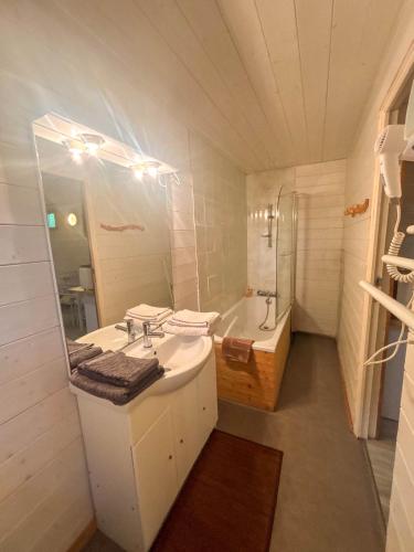 une salle de bain avec un lavabo, un miroir et une baignoire dans l'établissement Écolodge Les Sentiers du Lac - Domaine de la Gaïa, à Sorèze