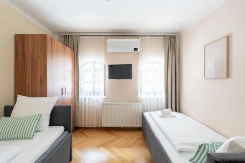 a small living room with a couch and a tv at Vienna Stay Apartments Schönbrunn in Vienna