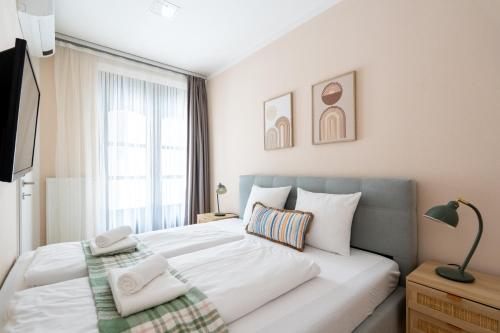a bedroom with a large white bed and a window at Vienna Stay Apartments Schönbrunn in Vienna